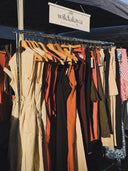 Clothing rack with various garments under a Wildalaya sign.